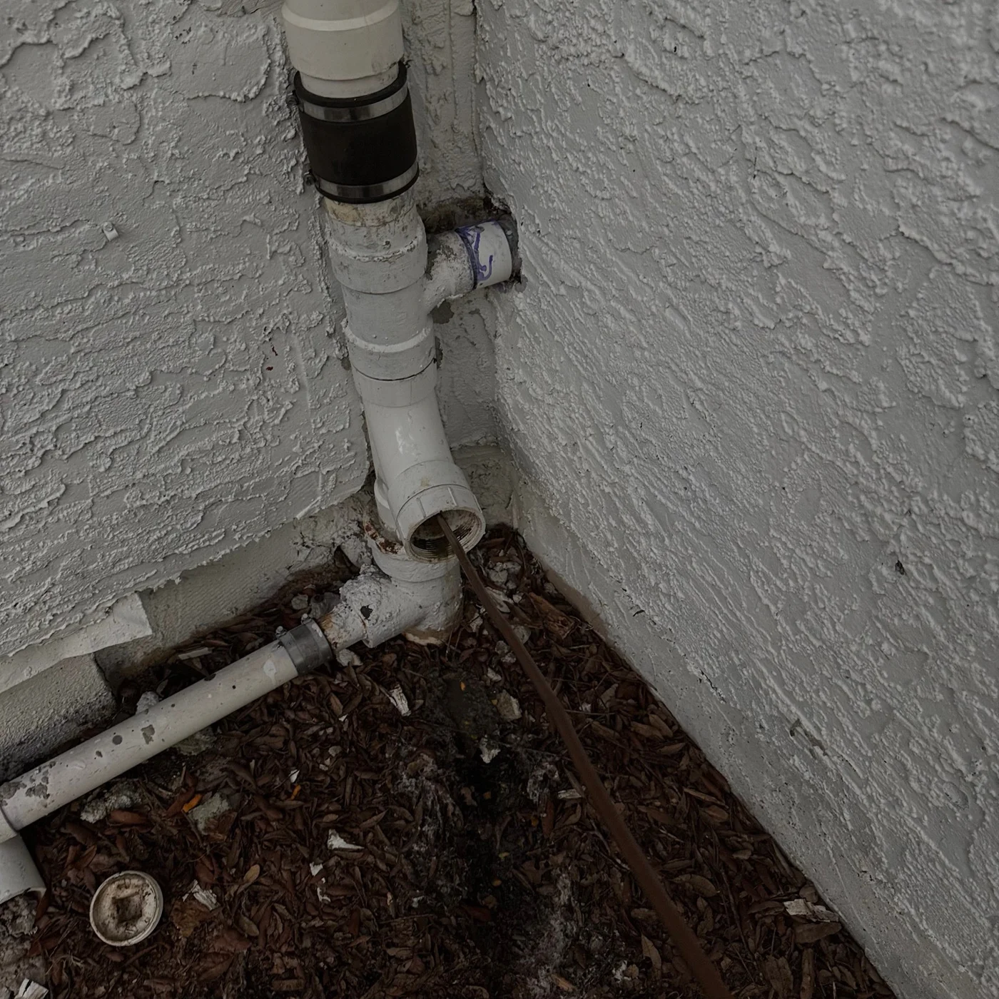 Service cable entering an exterior plumbing cleanout