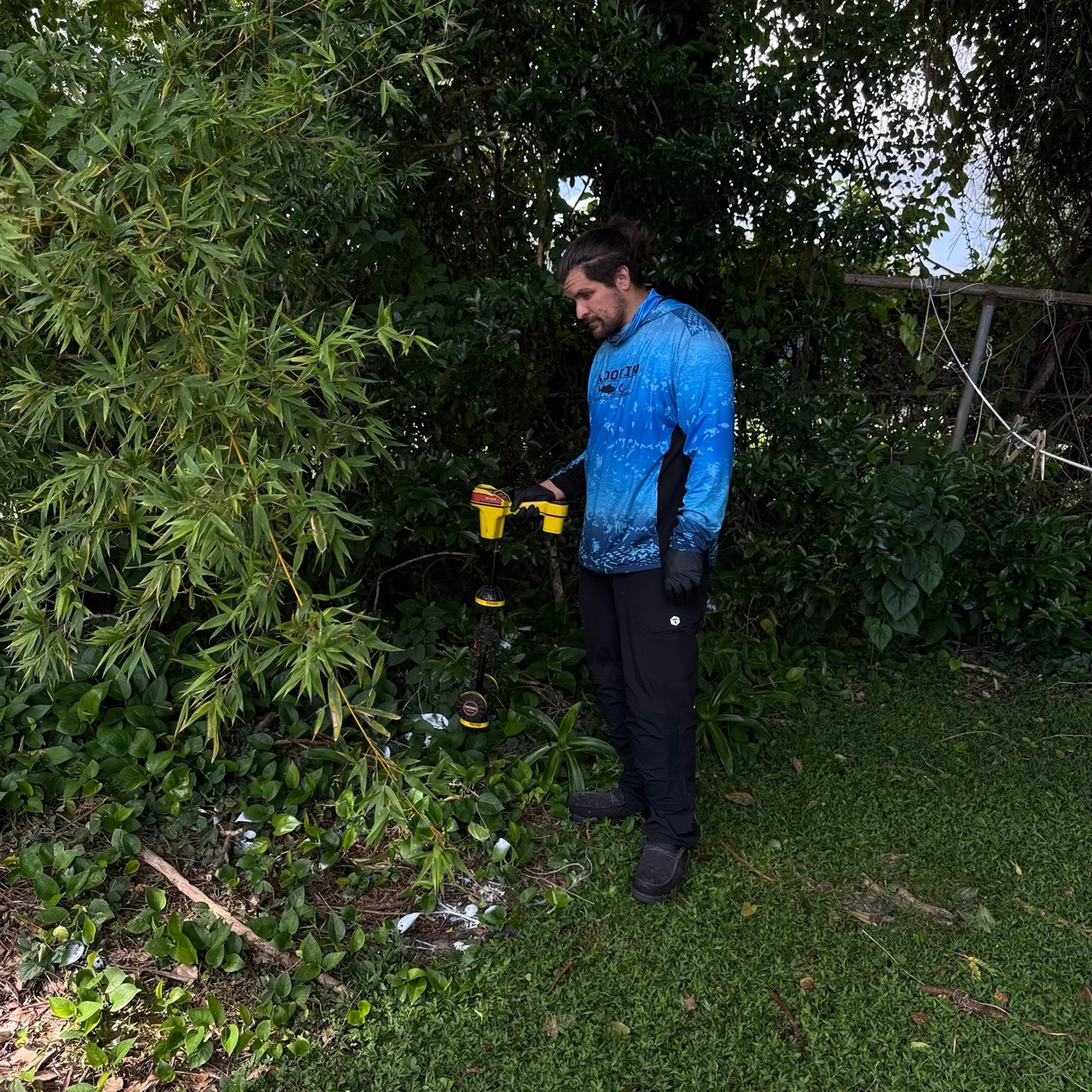 Technician using a handheld pipe locator outdoors